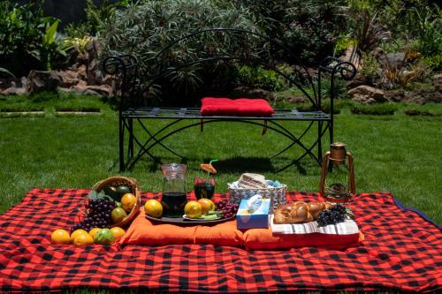 a picnic table with a platter of fruit on a blanket at Eldorado Rustic Hotel in Nakuru