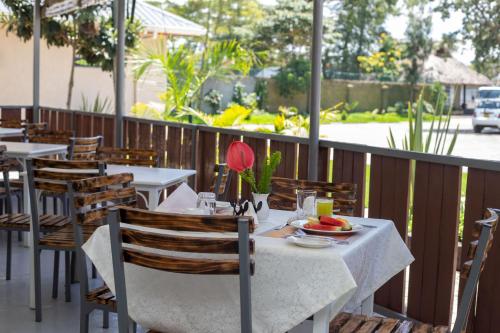 a table with a plate of fruit on a patio at Eldorado Rustic Hotel in Nakuru