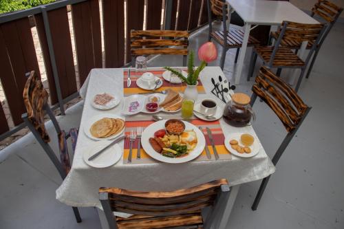 a table with a plate of breakfast food on a balcony at Eldorado Rustic Hotel in Nakuru