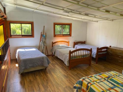 a bedroom with three beds in a room at Cabañas Mi Quincho in Parral