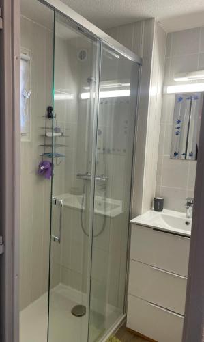 une douche en verre dans une salle de bain avec un lavabo dans l'établissement Charming duplex maisonette - Lv-Ll-Clim - Les Charmilles, aux Mathes