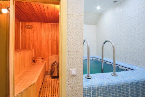 a bathroom with a tub and a swimming pool at ONOVO Dendra Hotel in Kyiv