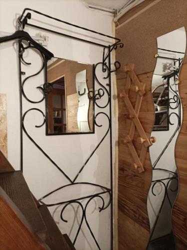 einen Spiegel an einer Wand mit einem Stuhl in einem Zimmer in der Unterkunft Atypique Briançon Cosy in Briançon