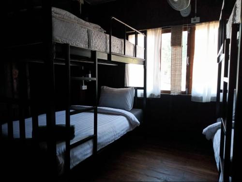 a bedroom with two bunk beds and a window at Imchai in Pai