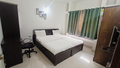 a small bedroom with a bed and a chair at Blue Ridge Service Apartments in Hinjewadi