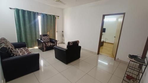 a living room with two chairs and a mirror at Blue Ridge Service Apartments in Hinjewadi