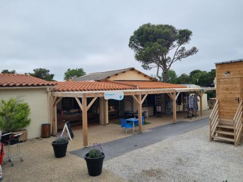 a house with a wooden pavilion in a yard at MOBILHOME SOLEIA NEUF 2023 MAR ESTANG SIBLU VILLAGE Canet-en-Roussillon in Canet-en-Roussillon