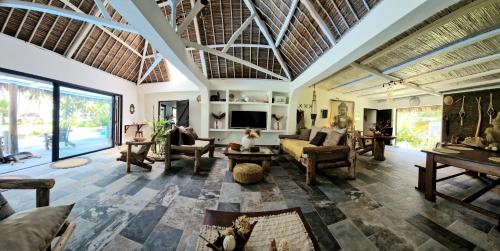 a living room with a couch and a tv at La VILLA BORAHA 300m2 PROPRIÉTÉ ENTIERE en bord de plage PISCINE PRIVEE Cuisine TV Wifi in Sainte Marie