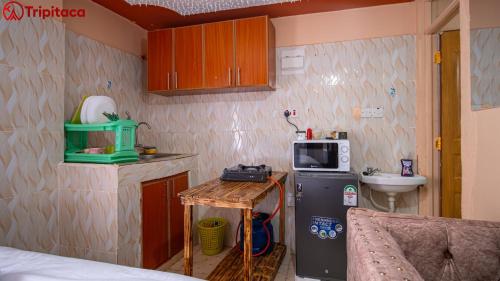 una pequeña cocina con microondas y nevera. en Hafy's studio apartments, en Nairobi