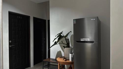 a stainless steel refrigerator in a room with a plant at 飛行船電梯民宿 in Taitung City