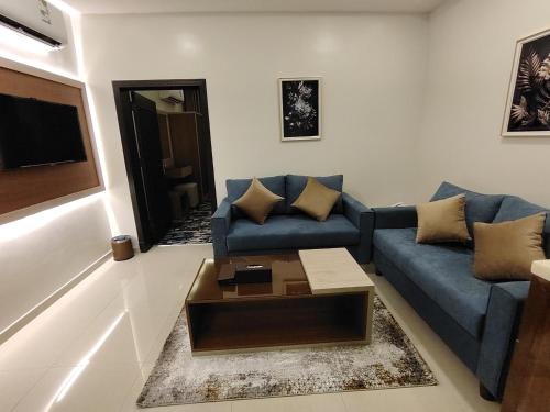 a living room with a blue couch and a coffee table at دريم بارك العليا in Al Khobar
