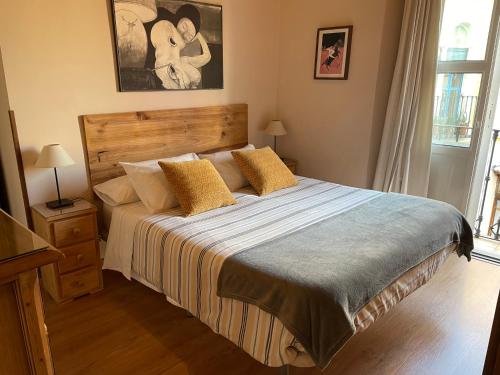 - une chambre avec un grand lit et des oreillers jaunes dans l'établissement VIVIENDA SAN AGUSTÍN, à Séville