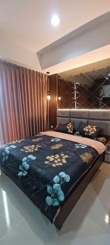 a bedroom with a bed with a blue comforter at Apartemen Nuvasa Bay in Nongsa