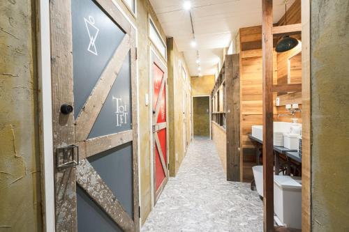 琴平的住宿－Kotori Coworking & Hostel Kotohira，走廊上设有带水槽的浴室和门