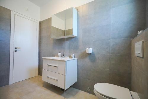 een badkamer met een wit toilet en een wastafel bij Villa Fiore in Žarović