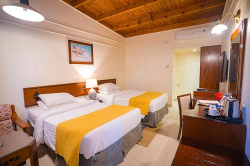 a hotel room with two beds and a desk at Nuweiba Club Resort in Nuweiba