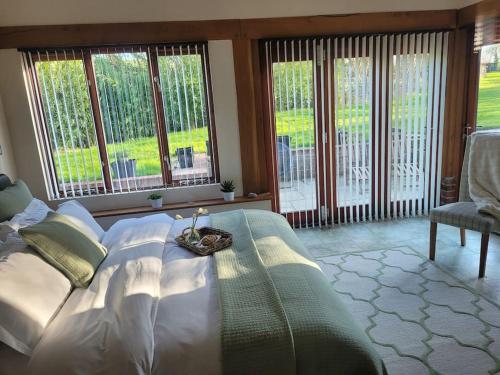 a bedroom with a large bed with a table on it at Honeysuckle Cottage Annex with hot tub near Needham Market in Needham Market