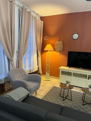 a living room with a couch and a television at L'évasion arrageoise 58 m² in Arras