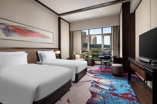 a hotel room with two beds and a flat screen tv at Crowne Plaza Chongqing New North Zone by IHG in Chongqing