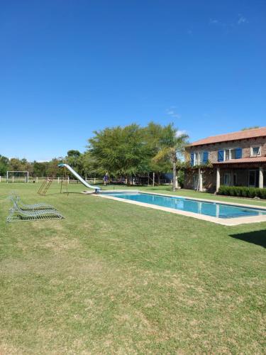 a swimming pool with a slide and a playground at Hartland Garden Suite in Oudtshoorn