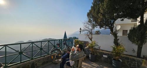 a couple of people taking a picture of the ocean at The Wilbury Homes in Mussoorie