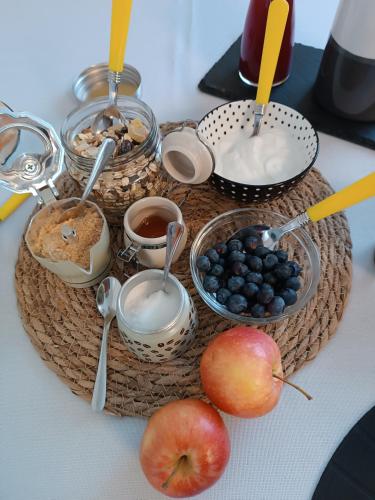 a tray of food with apples and blueberries on a table at Corte Giorgi in Breno