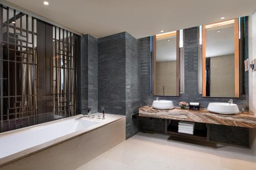 a bathroom with two sinks and a bath tub at Crowne Plaza Chongqing New North Zone by IHG in Chongqing