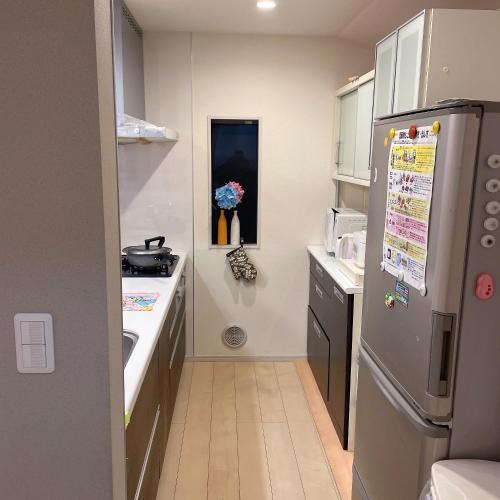 a small kitchen with a refrigerator and a sink at MiShe主题南行徳民宿 in Tokyo