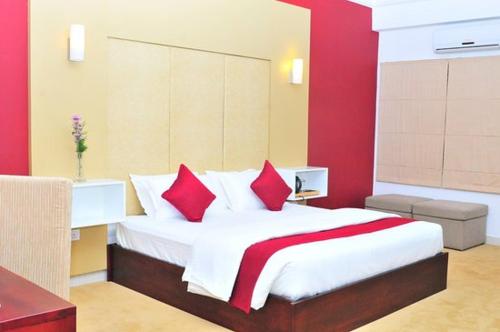 a bedroom with a large bed with red walls at Laa Adams - The Luxurious Living in Hatton