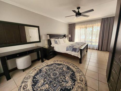 1 dormitorio con cama, escritorio y piano en Margate Manor en Pretoria