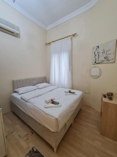 een slaapkamer met een bed met witte lakens en een raam bij Perla di Pera Hotel in Istanbul
