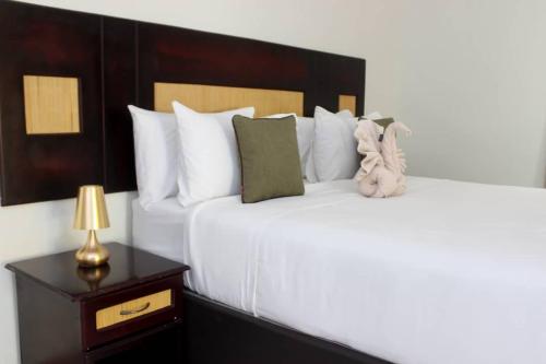 a bedroom with a large white bed with a night stand at Delta Sunset View in Maun