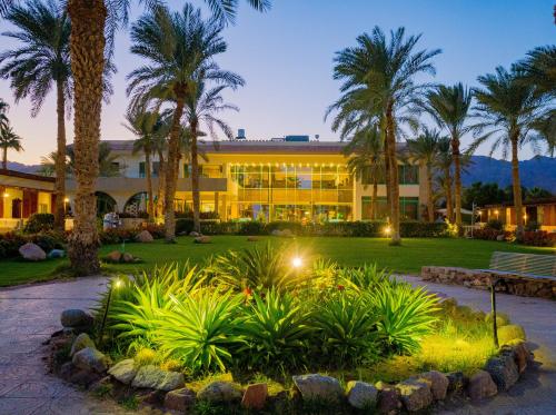 a building with palm trees in front of it at Nuweiba Club Resort in Nuweiba