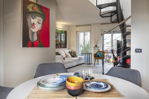 a dining room with a table and a painting on the wall at Amazing Design Apartment with Rooftop in Navigli - WiFi - Terraces - Garden in Milan