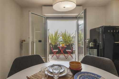 a dining room with a table and a view of a patio at Giresio 41 - Your Penthouse with Rooftop Garden in Milano Navigli - WIFI in Milan