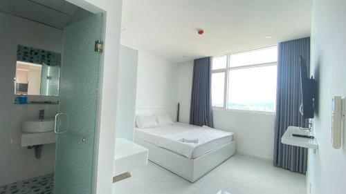 a white bathroom with a bed and a window at NHA TRANG COMFORTZONE APARTMENT in Nha Trang