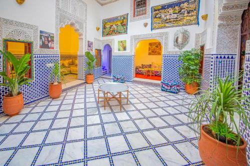 a room with potted plants and a table at Riad Rayhana in Fès