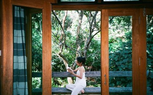 a woman in a white dress sitting on a bench at The River whisper in Ban Ton Kham