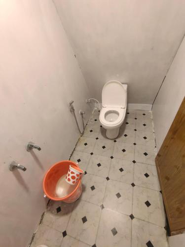 a bathroom with a toilet and a bucket in it at Papathi farm house in Kodaikānāl