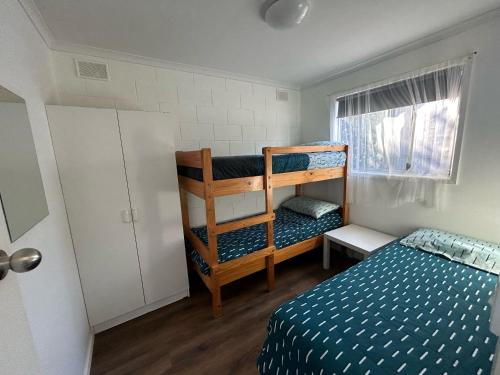 a bedroom with a bed and a bunk bed at Edithburgh Foreshore Apartments in Edithburgh