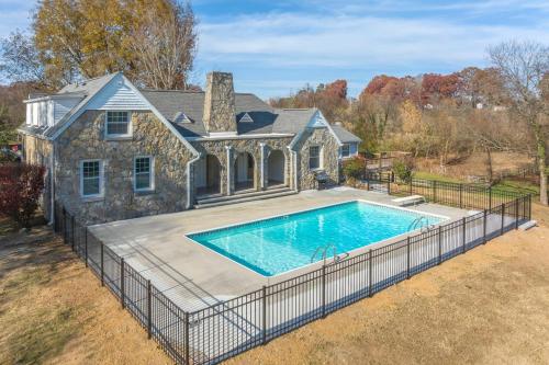 an image of a swimming pool in front of a house at Tranquil Mountain Escape Luxurious 5-Bedroom Farmhouse with Pool in Maryville