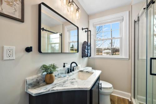 a bathroom with a sink and a mirror at Tranquil Mountain Escape Luxurious 5-Bedroom Farmhouse with Pool in Maryville
