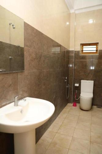 a bathroom with a sink and a toilet at Birunthavanam in Vavuniya