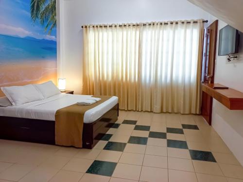a bedroom with a bed and a checkerboard floor at Castle Rock Apartelle in Boracay