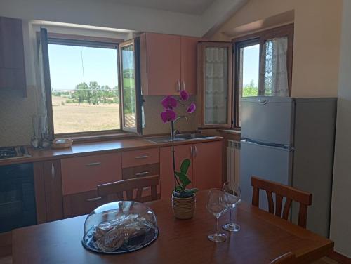 a kitchen with a wooden table and a refrigerator at Cascina del Poeta in Recanati