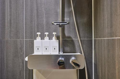 a bathroom with a soap dispenser in a shower at Urban Hotel 