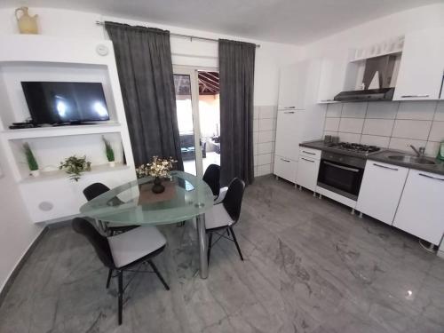 a kitchen with a glass table and chairs in a room at Tara in Korčula