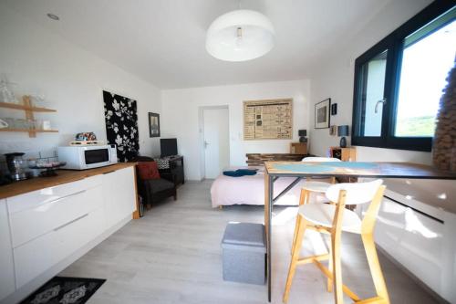 une cuisine et un salon avec une table et un lit dans l'établissement Horizon en Champagne, studio avec jardin et vue, à Germaine