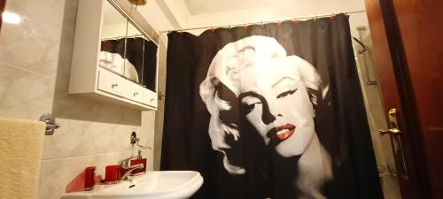 a bathroom with a shower curtain with a face on it at Casa Alencastre in Funchal