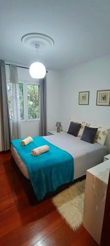 a bedroom with a large bed with a blue blanket at Casa Alencastre in Funchal